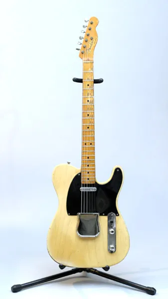 Butterscotch blonde Telecaster with a black pickguard on a stand
