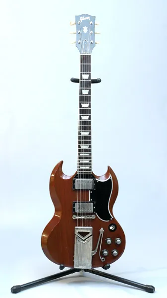 Brown 1961 Gibson SG with a vibrato tailpiece on a stand