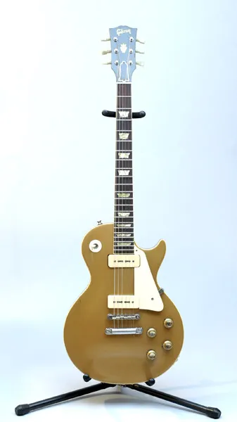 Gold top Gibson Les Paul with P-90 pickups on a stand