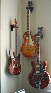 Three guitars hanging on a wall