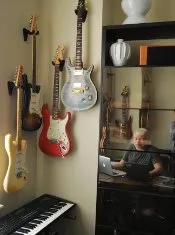 Guitars hanging in the music room beside a keyboard