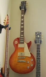 A cherry sunburst Les Paul hanging on the wall