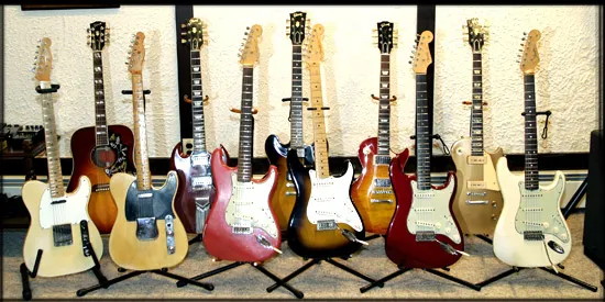 A row of vintage Fender and Gibson guitars on stands