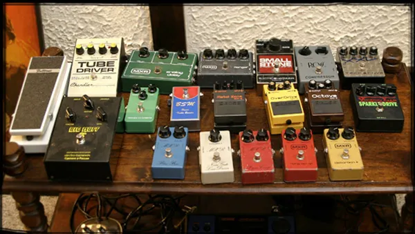 Rows of vintage effect pedals on a wooden table