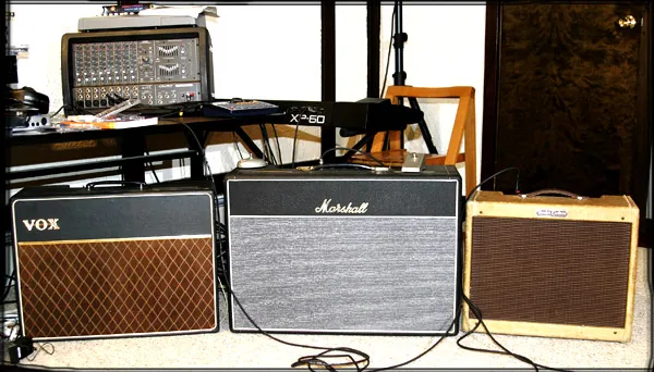 A Vox, a Marshall, and a tweed Fender amp side by side